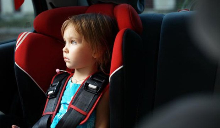 A child in a car seat without a jacket